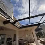 Dark bronze pool cage roof beams and new screens over a covered lanai in Windermere, FL