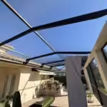 Looking up through new screens at a restored pool cage roof beside an outdoor kitchen in Windermere, FL