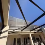 Tall restored pool enclosure with dark bronze roof beams and new screens in Windermere, FL