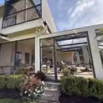Restored screen enclosure below a second-floor balcony on a Windermere, FL home