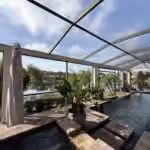 Inside a restored pool cage in Windermere, FL, with all-new screens and a lake view past the pool