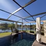Rescreened pool enclosure with a dark bronze frame overlooking a lake in Windermere, FL